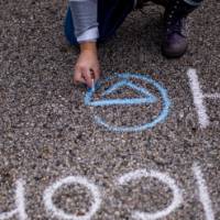 Emily Miller writes a message in chalk at the tailgate